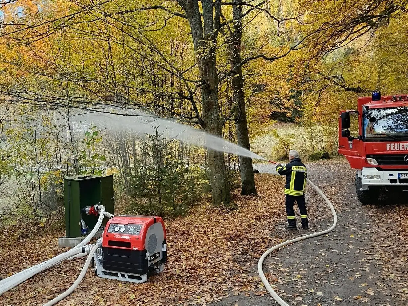 Löschwasserprobeeinsatz zur Einweihung der Trockensteigleitung am Großen Zschand; ein Feuerwehrmann spritzt Wasser