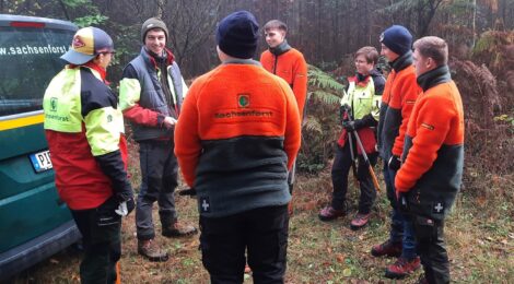 Lehrausbilder Karl Metzner (2. v. l.) und die sechs neuen Forstwirt-Azubis der Nationalpark- und Forstverwaltung von Sachsenforst besprechen ihren bevorstehenden Einsatz in der Jungbestandspflege. Der junge Mischwald im Hintergrund muss aufgelichtet werden. Foto: Hanspeter Mayr