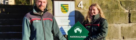 Christian Starke übergibt mit einem Nationalparkschild symbolisch die Leitung für den Fachbereich Naturschutz, Gebietsentwicklung und Forschung an Astrid Scharf. Sie arbeitete bereits acht Monate in diesem Bereich, bevor sie nun die Leitung übernahm. Starke ist seit vergangenem Jahr Leiter des Wildnisgebiets auf dem ehemaligen Truppenübungsplatz Königsbrück. Foto: H. Mayr